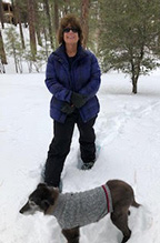 Woman Posing for Photo with Dog in Deep Snow